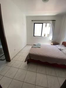 ein weißes Schlafzimmer mit einem Bett und einem Fenster in der Unterkunft Hotel Menegatti in Pato Branco