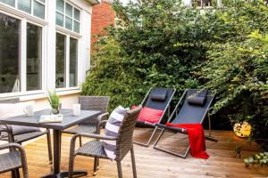 een terras met een tafel en stoelen op een dek bij Logierhaus K15 Appartement 1 in Borkum