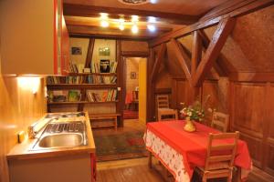 cocina con fregadero y mesa con mantel rojo en Couleurs Nature, en Thanvillé