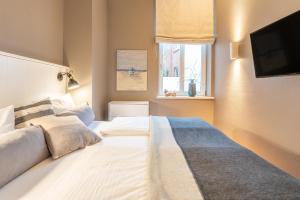 een slaapkamer met twee bedden en een flatscreen-tv bij Logierhaus K15 Appartement 2 Plus in Borkum