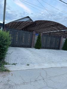 a building with black gates in front of a driveway at Роща 7 in Bishkek