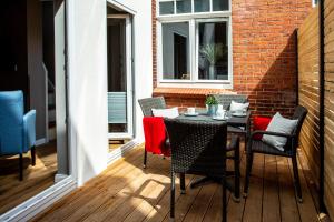 een terras met een tafel en stoelen op een balkon bij Logierhaus K15 Appartement 2 Plus in Borkum