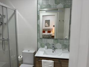 a bathroom with a sink and a toilet and a mirror at Orange Suite By Alhaurín Loft City in Alhaurín de la Torre +22 photos