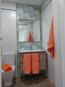a bathroom with a sink and a toilet and a mirror at Orange Suite By Alhaurín Loft City in Alhaurín de la Torre