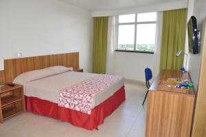 a bedroom with a bed and a desk at Boa Vista Eco Hotel in Boa Vista
