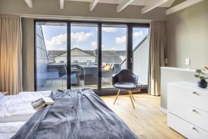 een slaapkamer met een bed en een stoel en een groot raam bij InselLoft Wohnung 4 in Borkum +8 foto's