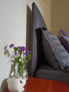 a table with a vase with purple flowers in it at KhaoSok Farmstay in Khao Sok National Park