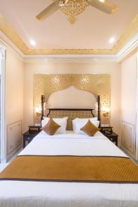 ジャイプールにあるUmrao Mahal - A Boutique Heritage Hotel & Resort Jaipurの部屋にある大きな白いベッドのある寝室