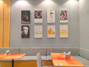 a living room with a couch and a wall with pictures at Ivy Hotel Aromire in Hausa
