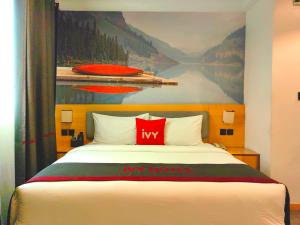 una camera da letto con un letto e un dipinto sul muro di Ivy Hotel Aromire a Hausa