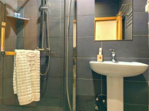 un bagno con lavandino e doccia di Ivy Hotel Aromire a Hausa