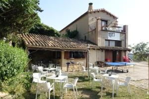 un grupo de mesas y sillas frente a un edificio en Casa Atuel, en Bierge