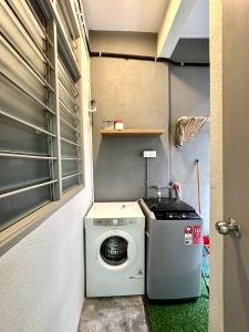 新邦安拨Charming 4BR Family House Quite Area & Cozy的小房间里的洗衣机和烘干机