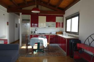 una cucina con mobili rossi e un tavolo in una stanza di Casa Atuel a Bierge