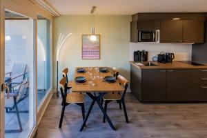 una cucina e una sala da pranzo con tavolo e sedie di Surfers Oase near Interlaken at lake with pool a Därligen