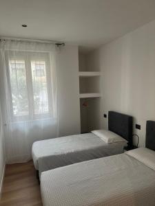 a bedroom with two beds and a window at White Swan Apartment in Peschiera del Garda