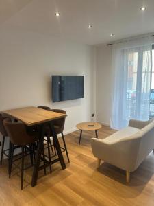 a living room with a table and chairs and a television at White Swan Apartment in Peschiera del Garda