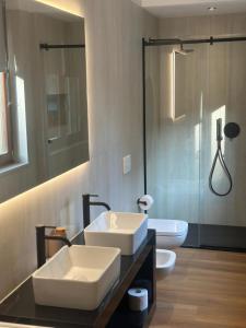 a bathroom with two white sinks and a shower at White Swan Apartment in Peschiera del Garda +18 photos