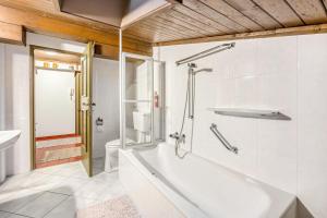 ein Badezimmer mit einer weißen Badewanne und einem WC in der Unterkunft Maxls Stubn in Maria Alm am Steinernen Meer