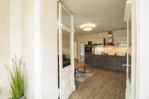 a kitchen and living room with a open door at Brise Villa Emmi App 04 in Heringsdorf