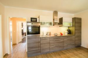 a kitchen with stainless steel appliances and wooden floors at Brise Villa Emmi App 04 in Heringsdorf +10 photos