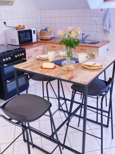 a kitchen with a wooden table and two chairs at Appartement au calme - T3, Ancenis, A11 in Mésanger
