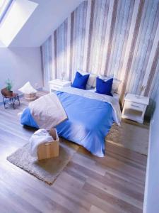 a bedroom with a bed with blue sheets and blue pillows at Appartement au calme - T3, Ancenis, A11 in Mésanger
