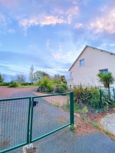 a fence in front of a white house at Appartement au calme - T3, Ancenis, A11 in Mésanger