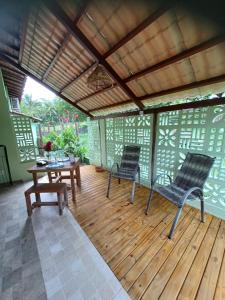 two chairs and a table on a wooden deck at Cafofo de Dri in Ilha de Boipeba +15 photos