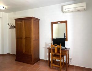 a room with a wooden cabinet and a desk with a mirror at Hotel San Julian in Burunchel