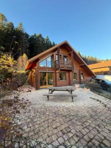 Le Chalet des Vanneaux في كسونبورت-لونجمير: منزل أمامه طاولة نزهة