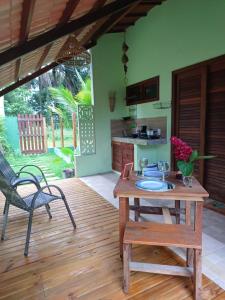 a patio with a table and a chair and a kitchen at Cafofo de Dri in Ilha de Boipeba
