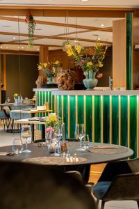 a restaurant with tables with wine glasses on them at La Suite Appart Hôtel in Roanne
