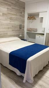 ein Schlafzimmer mit einem großen Bett mit einer blauen Decke in der Unterkunft Hospederia IMAR by Cadiz4Rentals in Cádiz
