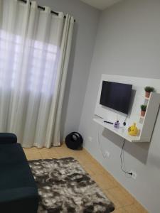 un soggiorno con monitor per computer su una scrivania di Casa á 5 minutos do Paraquedismo a Boituva