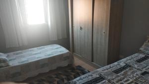 una piccola camera con due letti e un armadio di Casa á 5 minutos do Paraquedismo a Boituva