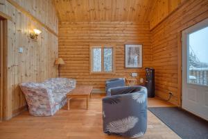 a living room with a chair and a table at Chalet Cerf for 16 Guests, 7 min to SPA, Skiing in Saint-Paul-de-Montminy