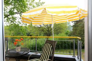 a patio table and chairs under an umbrella on a balcony at Brise Haus "Am Schloonsee" App 05 in Bansin