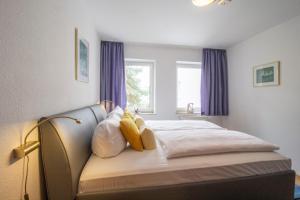 a bedroom with a bed with pillows and a window at Brise Haus "Am Schloonsee" App 05 in Bansin +7 photos