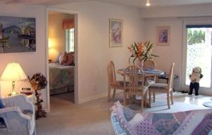 a living room with a table and chairs and a bedroom at River Cove Elegant Waterfront Bed & Breakfast in Post Falls