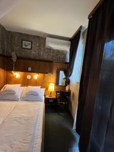 um quarto com uma cama e uma secretária com uma janela em Villa Sagan em Zamárdi