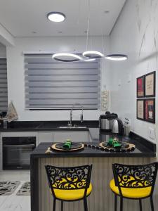 une cuisine avec deux chaises jaunes et un comptoir dans l'établissement Apartamento Moderno Paraquesdismo e Balão, à Boituva