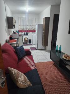 un soggiorno con divano e cucina di Apto 32. Lindo, aconchegante e completo. a Boituva