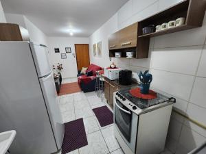 una cucina con frigorifero e fornello forno superiore di Apto 32. Lindo, aconchegante e completo. a Boituva