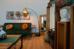 威尼斯Flora Relax - Venice Green House的客厅里有一张绿色的沙发和一张桌子