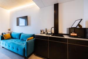 耶斯特滕Motel Q的客厅里有一张蓝色沙发和一台电视