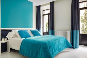 a blue bedroom with a bed with blue sheets at Don Cecilio Guesthouse (Centro) in Donostia-San Sebastián
