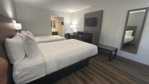 a hotel room with two beds and a mirror at Econo Lodge Daytona Beach - Speedway in Daytona Beach