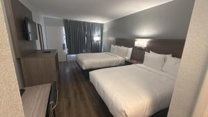 a hotel room with two beds and a television at Econo Lodge Daytona Beach - Speedway in Daytona Beach