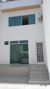 ein weißes Gebäude mit einem Fenster und einer Treppe in der Unterkunft Hospedagem próxima ao centro apto simples in Feira de Santana